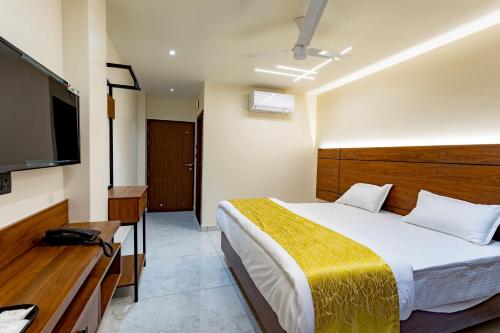 a bedroom with a bed and a flat screen tv at Uphills boutique hotel in Kallar Vattiyar