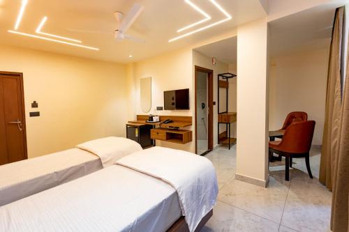 a hotel room with two beds and a desk at Uphills boutique hotel in Kallar Vattiyar