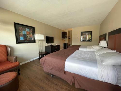 a hotel room with a large bed and a chair at Rondo Motel in Golden