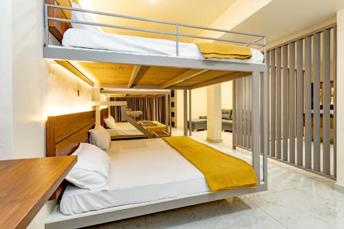 a room with two bunk beds and a desk at Uphills boutique hotel in Kallar Vattiyar