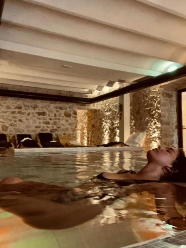 a woman is laying in a swimming pool at Grand Hotel & des Anglais Spa in Sanremo