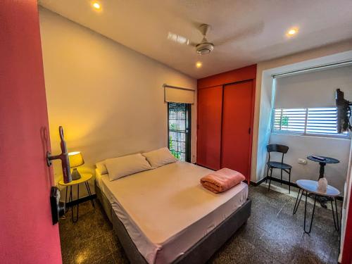 a small bedroom with a bed and a window at Fardo Hotel Boutique Ibague - Recepción Digital 24H in Ibagué