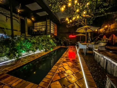 a pool with a table and an umbrella in a building at Fardo Hotel Boutique Ibague - Recepción Digital 24H in Ibagué