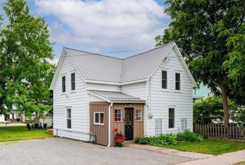 a white house with a gambrel roof at Charming cottage in the heart of Wellington in Wellington