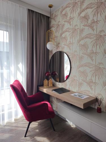 escritorio con silla roja y espejo en Bel Mare apartament prywatny Milamare Parking gratis, en Międzyzdroje