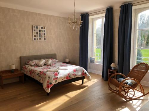 a bedroom with a bed and two windows at Abbaye de l'Etanche - Un cadre naturel exceptionnel - Patrimoine - in Rollainville
