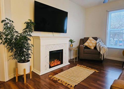 a living room with a fireplace with a television above it at Charming cottage in the heart of Wellington in Wellington