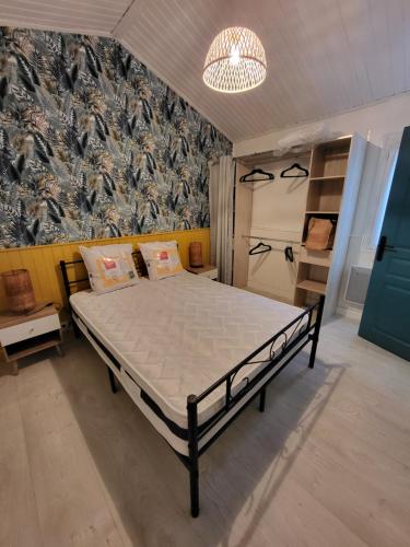 - une chambre avec un lit dans une pièce avec un mur dans l'établissement JujuJajaCo, à Grand-Village-Plage
