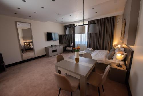a living room with a bed and a table and chairs at Hotel Sun Loznica in Loznica