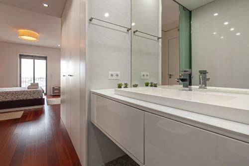 a bathroom with two sinks and a large mirror at Palace by Home Sweet Home Aveiro in Aveiro