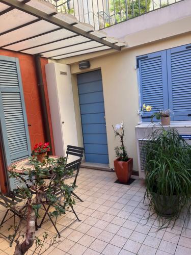 a patio with blue doors and a table with plants at Joli studio à Monaco in Beausoleil