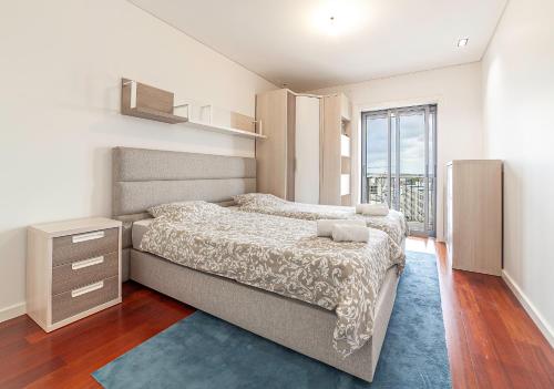 een slaapkamer met een bed en een groot raam bij Palace by Home Sweet Home Aveiro in Aveiro