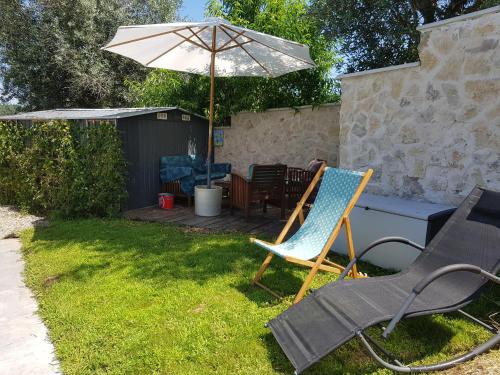 une terrasse avec un parasol, deux chaises et une table dans l'établissement QUINTA FENIX - Chambre Olivia, à Cerejeiras