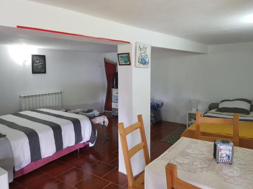 Cette chambre comprend deux lits, une table et un lit. dans l'établissement QUINTA FENIX - Chambre Olivia, à Cerejeiras