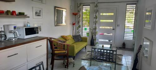a kitchen with a living room with a yellow couch at Breezy La Vista on the Terrace in Saint James