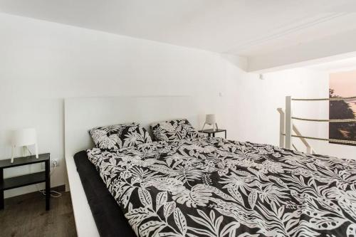 1 dormitorio con 1 cama con edredón blanco y negro en 57 Steps from the Basilica, en Budapest