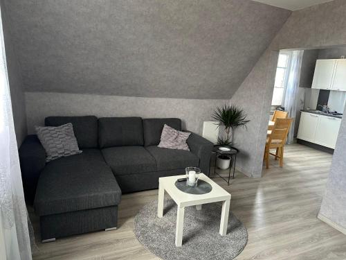 ein Wohnzimmer mit einem Sofa und einem Tisch in der Unterkunft Ferienzimmer Becker(Nordzimmer) in Werdum