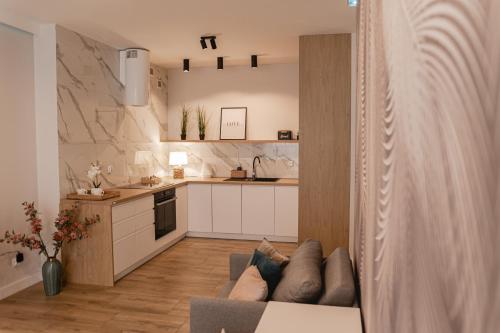 kuchnia i salon z kanapą w pokoju w obiekcie Apartament Rozmarynowa Residence 8 Opole w mieście Opole