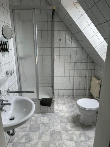 ein Bad mit einer Dusche, einem WC und einem Waschbecken in der Unterkunft Ferienzimmer Becker(Nordzimmer) in Werdum