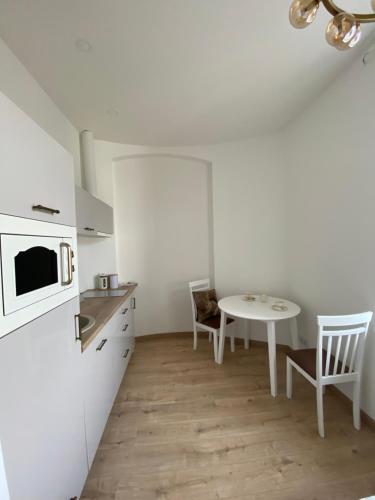 eine Küche mit einem Tisch und einem weißen Kühlschrank in der Unterkunft Golden Rush in Riga