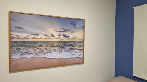 a picture of the ocean on a wall at Alto Luxo colado no Shopping in Franca