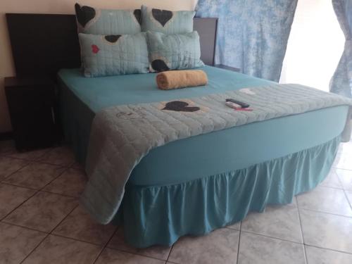 a blue bed with a blue skirt on it at comfort zone guest house in Zeerust