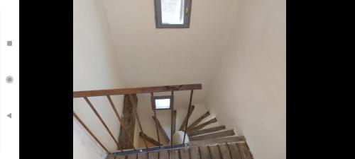 a wooden staircase in a building with a window at Maison intra muros, terrasses avec vue jaccuzzi et garage in Avignon