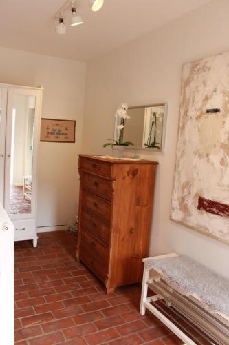 a room with a wooden dresser and a mirror at Bjerred B&B in Bjärred