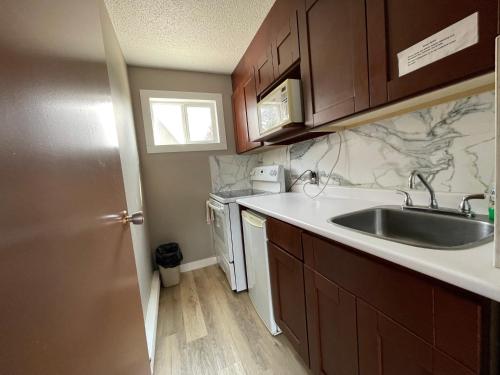 a small kitchen with a sink and a dishwasher at Rondo Motel in Golden