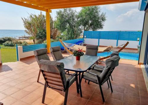 a patio with a table and chairs and the ocean at Villa Marina in Ayia Thekla with Heated Pool in Ayia Napa