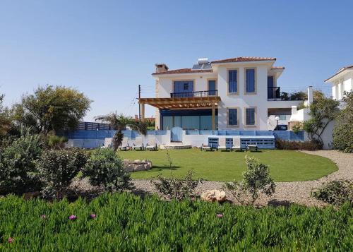 a large white house with a yard with a lawn sidx sidx sidx at Villa Marina in Ayia Thekla with Heated Pool in Ayia Napa