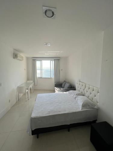 a white bedroom with a bed and a couch at Apartamento em copacabana VISTA MAR in Rio de Janeiro