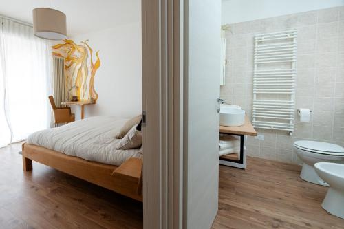 a bedroom with a bed and a toilet and a sink at Casa vacanze Filos in Pergine Valsugana