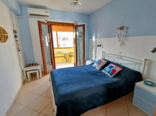 een slaapkamer met een bed met een blauw dekbed bij Agapi Studio Acharavi à 50m de la mer, 400m du centre ville in Acharavi