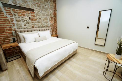 a large bed in a room with a brick wall at MONOPATI HOUSE in Mouzákion