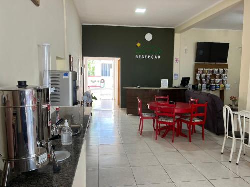 a restaurant with a red table and red chairs at Nostra Cuesta Hostel in Botucatu