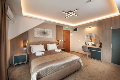 ein Schlafzimmer mit einem großen Bett und einem Schreibtisch in der Unterkunft Hotel Kralj in Kraljevo
