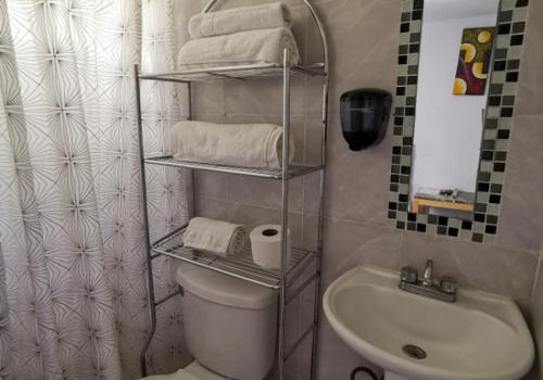 a bathroom with a toilet and a sink and towels at MINI HOTEL San Luis Potosí in San Luis Potosí