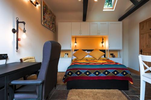 een slaapkamer met een bed, een tafel en een bureau bij Cosy countryside retreat - Pogo in Milton Keynes