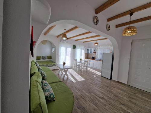 a living room with a green couch and a kitchen at Seva's House in Psinthos