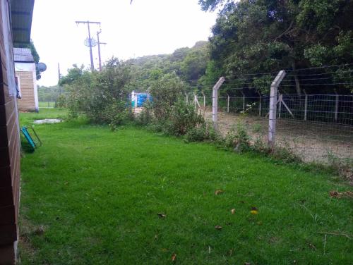 a fence in a yard with a field of grass at Inature in Florianópolis