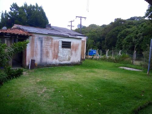 uma casa velha com um jardim de relva em frente em Inature em Florianópolis