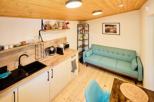 eine Küche mit blauem Sofa in einem Zimmer in der Unterkunft Privátní chata Dori se saunou v ceně in Kouty