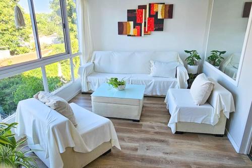 sala de estar con muebles blancos y ventana grande en Departamento PH en Martinez en Martínez