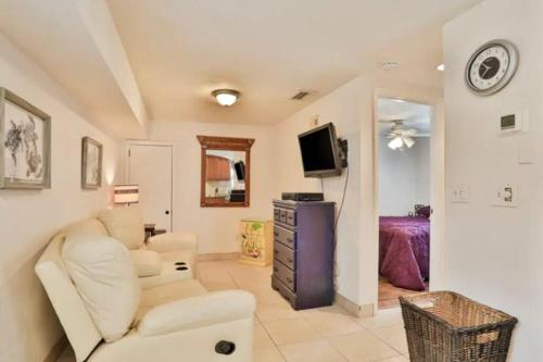 a living room with a white couch and a tv at Summer Sands Lodge U1 in Flagler Beach