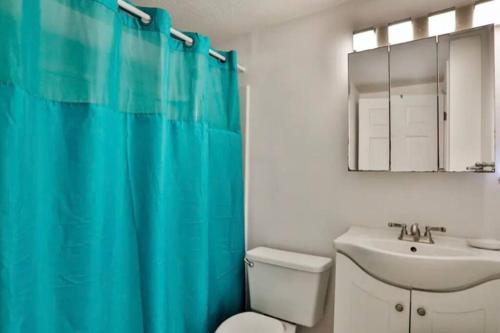 a bathroom with a blue shower curtain and a sink at Summer Sands Lodge in Flagler Beach