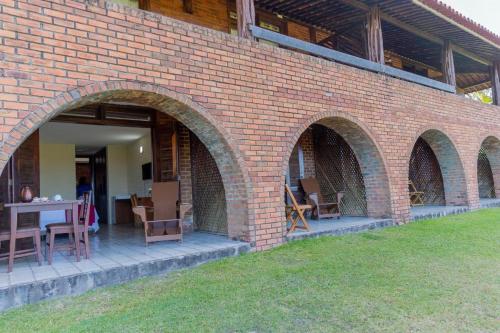 a brick building with a table and chairs on it at Hotel Praia dos Carneiros in Tamandaré