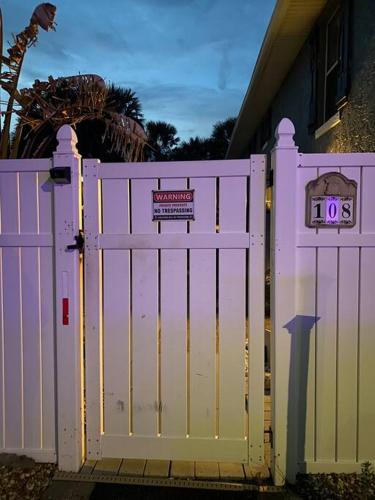 a white gate in front of a house at Summer Sands Lodge U1 in Flagler Beach