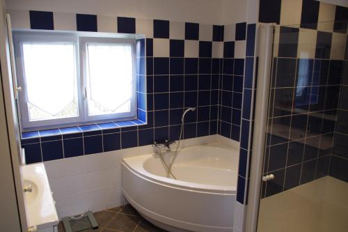 a bathroom with a bath tub and a window at Villa Audresselles in Ambleteuse