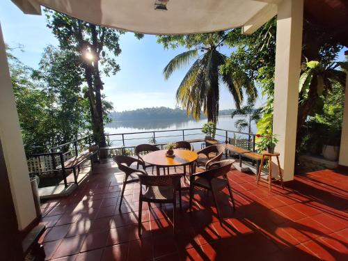 BandaragamaにあるMyHoliday Home @ Bandaragamaのテーブルと椅子、水辺の景色を望むバルコニー